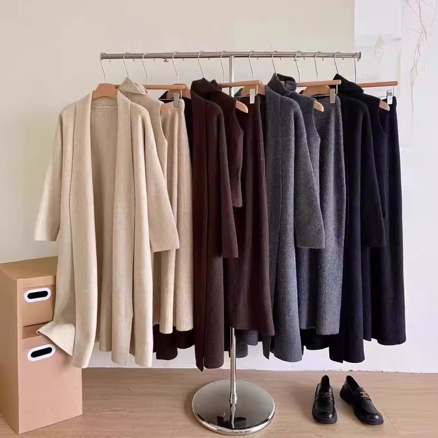 Clothing rack with various colored sweaters on a wooden floor.