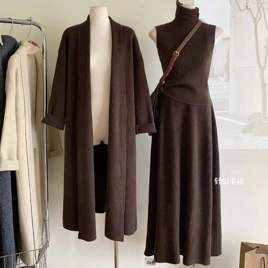 Brown coat and dress set on mannequins with a blurred indoor background
